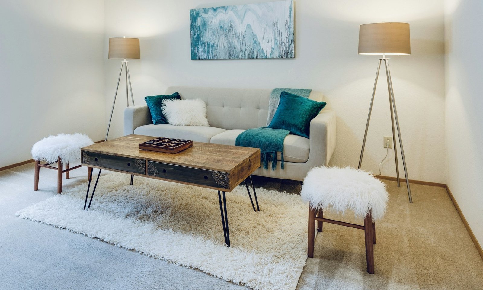 A bright living room with cream seating and an oak floor