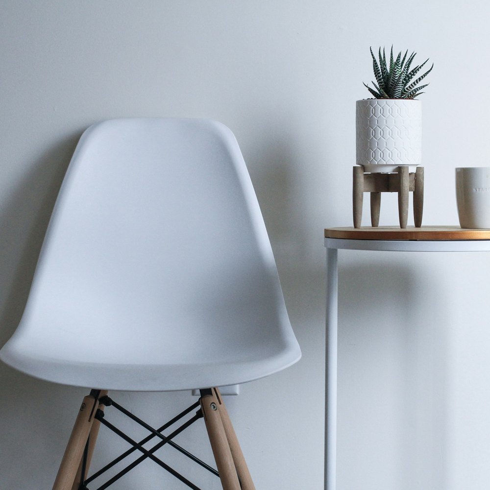 A moulded chair beside a side table